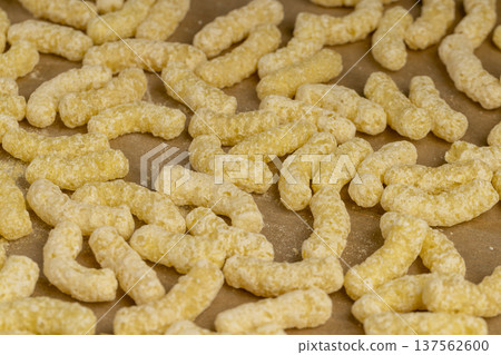 yellow large sweet sticks of corn flour with added sugar for quick cooking with milk or yogurt, ready-to-eat corn sticks scattered on food paper, close up yellow large sweet sticks of corn flour with added sugar for quick cooking with milk or yogurt, ready-to-eat corn sticks scattered on food paper, close up 137562600
