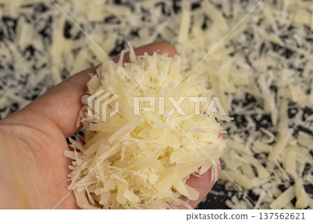 hard ripe cheese grated into small pieces for cooking pasta , grated piece of yellow quality cheese as an ingredient for a large dish 137562621
