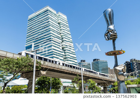A train on the Wenhu or Brown Line of the Taipei MRT passes by the modern metropolis building in Nangang Software Park Area. 137562903