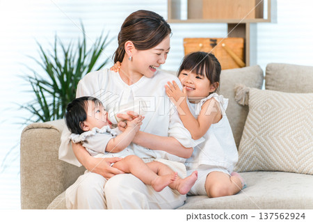 母親抱著嬰兒在沙發上，媽媽（育兒，全職家庭主婦） 137562924