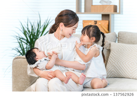 母親抱著嬰兒在沙發上，媽媽（育兒，全職家庭主婦） 137562926