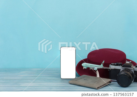 Travel Vibes. Smartphone, camera, and hat on blue background. Travel Vibes. Smartphone, camera, and hat on blue background. 137563157