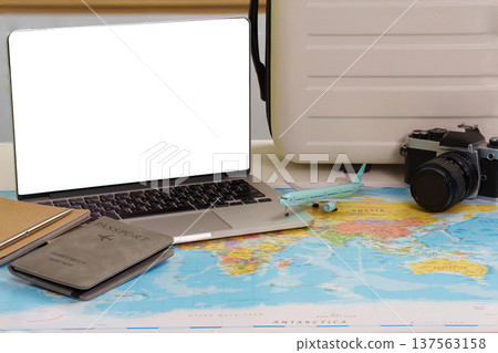 Travel Setup. Laptop, passport, and camera on world map. 137563158