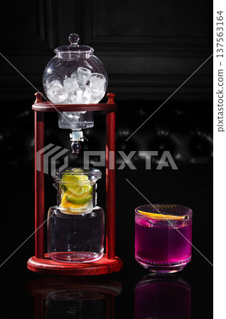 It looks like a coffee siphon, but now for a cocktail in a glass with pink-purple liquid It looks like a coffee siphon, but now for a cocktail in a glass with pink-purple liquid 137563164
