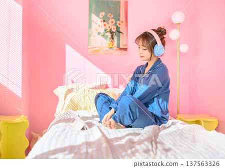 Woman listening to music in bed: Happy Pop Woman listening to music in bed: Happy Pop 137563326
