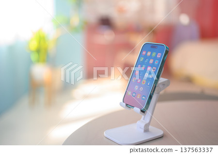Smartphone placed on a smartphone stand: Happy Pop Smartphone placed on a smartphone stand: Happy Pop 137563337