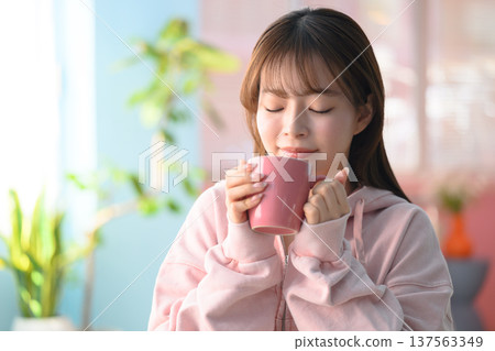 Close-up of a woman smelling a mug: Happy Pop 137563349