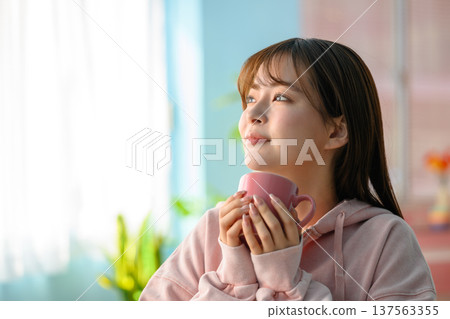 一位微笑的女士手捧馬克杯：快樂流行樂 137563355