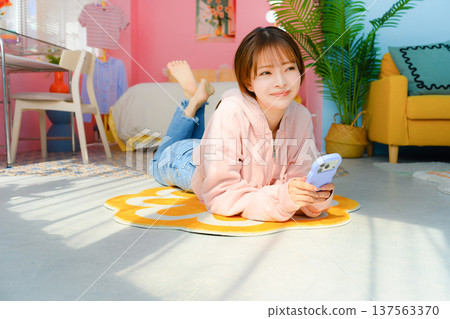 一位放鬆的女士正在看她的智慧型手機:快樂流行樂 一位放鬆的女士正在看她的智慧型手機:快樂流行樂 137563370