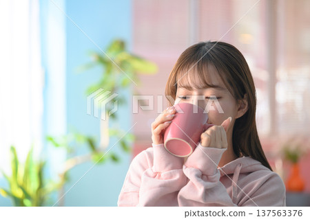 Woman drinking from a mug: Happy Pop 137563376