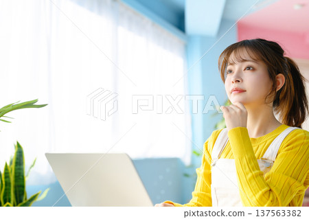 A young woman using a laptop by the window: Happy Pop 137563382