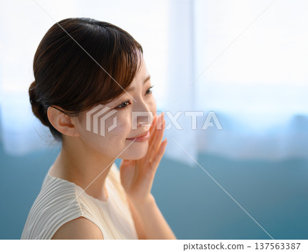 A woman holds her hand to her cheek to check her skin: Happy Pop A woman holds her hand to her cheek to check her skin: Happy Pop 137563387