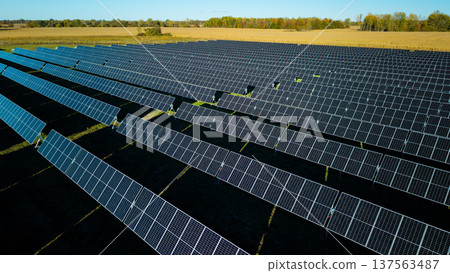 Aerial view of large solar power plant with rows of photovoltaic panels in rural landscape producing renewable electricity Aerial view of large solar power plant with rows of photovoltaic panels in rural landscape producing renewable electricity 137563487