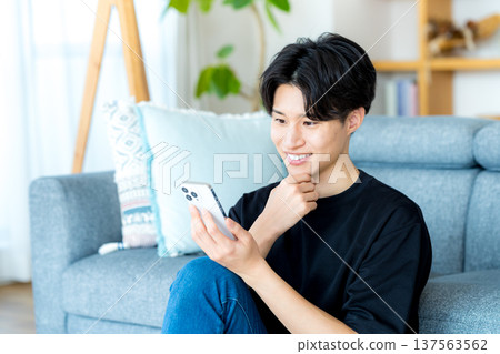 操作智能手機的一個年輕人 137563562