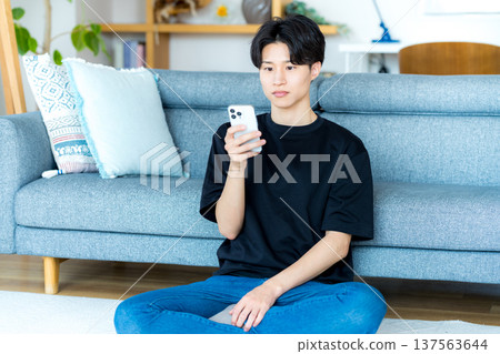 操作智能手機的一個年輕人 137563644