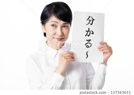 一位身穿白襯衫的老婦人雙手拿著一張寫著「我明白了」的紙，面帶微笑。 137563651