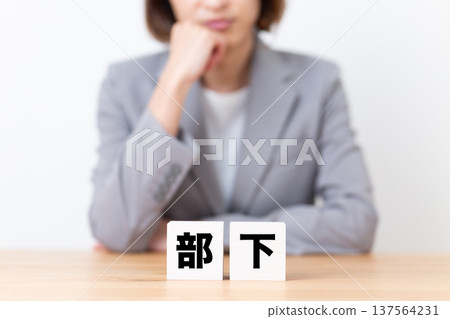 A middle-aged woman in a suit who is worried about her subordinate's block 137564231