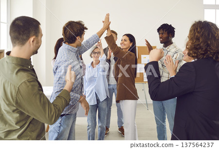Team of happy diverse business people celebrating success, having fun and high fiving each other Team of happy diverse business people celebrating success, having fun and high fiving each other 137564237