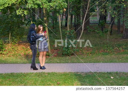 Girlfriends young women discussing the news, looking at the phone 137564257