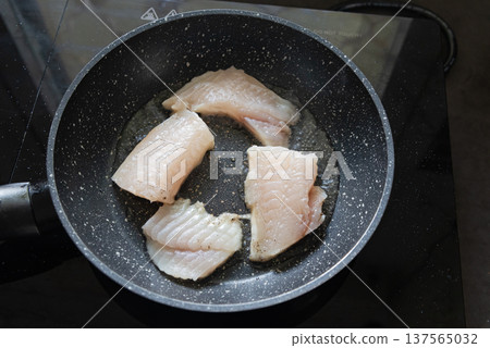 Fish fillet frying in pan on kitchen stove Fish fillet frying in pan on kitchen stove 137565032
