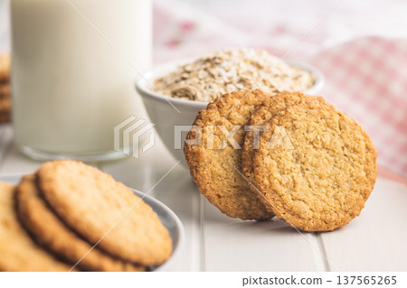 Fresh baked cookies and oats with a glass of milk on a table in a cozy kitchen setting during the day Fresh baked cookies and oats with a glass of milk on a table in a cozy kitchen setting during the day 137565265