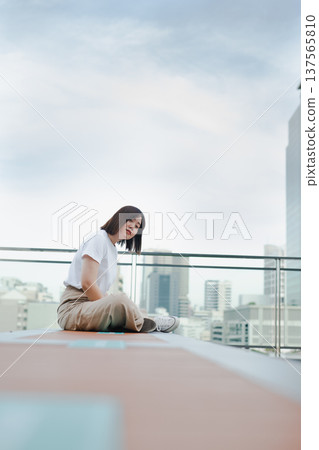 solo asian woman outdoor break and relax with smile and happy feeling at rooftop with city background solo asian woman outdoor break and relax with smile and happy feeling at rooftop with city background 137565810
