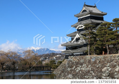 Matsumoto Castle stands tall in pitch black against the backdrop of the Northern Alps in winter 137565858