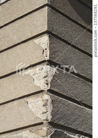 Old weathered building corner with damaged plaster 137568291