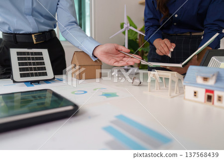 Sustainability and ESG. Business professionals analyzing renewable energy models and strategies. 137568439