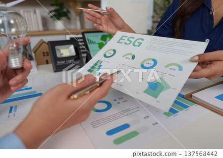 Sustainability and ESG. Professionals discussing environmental strategies with charts and data. Sustainability and ESG. Professionals discussing environmental strategies with charts and data. 137568442