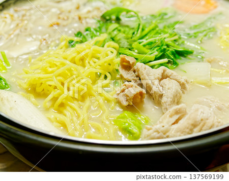 一鍋熱氣騰騰的白湯麵，裡面有蔬菜和麵條，是冬天裡溫暖的一餐。 137569199