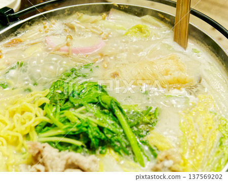 一鍋熱氣騰騰的白湯麵，裡面有蔬菜和麵條，是冬天裡溫暖的一餐。 137569202