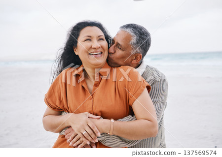 Beach, hug and senior happy couple kiss, support and care on travel holiday, retirement vacation and affection in nature. Embrace, freedom and romantic elderly man, old woman or marriage people bond 137569574