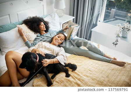 Dog, bed and happy lesbian couple in home, morning and relax together reading book. Pet, bedroom and gay women with animal, bonding and play in healthy relationship, love connection and interracial Dog, bed and happy lesbian couple in home, morning and relax together reading book. Pet, bedroom and gay women with animal, bonding and play in healthy relationship, love connection and interracial 137569791
