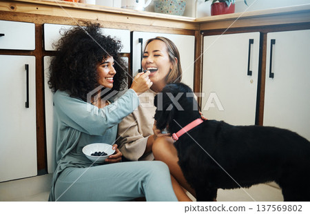 Lesbian, couple and happy with dog in kitchen, home or women eating breakfast together on the floor of apartment. Pet, animal and people with cereal or food in house with love, care and support Lesbian, couple and happy with dog in kitchen, home or women eating breakfast together on the floor of apartment. Pet, animal and people with cereal or food in house with love, care and support 137569802