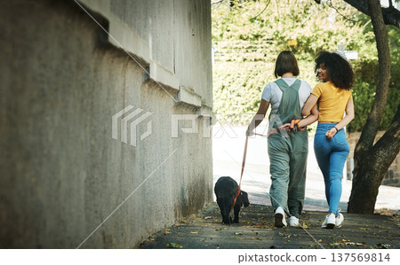 Women, walking and couple with a dog in street, park or portrait outdoor in spring with pet on lead and wall mockup space. People, smile and journey with animal for exercise, wellness or happiness 137569814