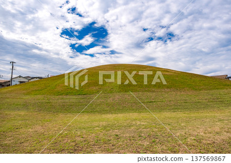 The grass-covered mound of the historic Kotsubo Kofun burial mound in Kobe, Hyogo Prefecture 137569867