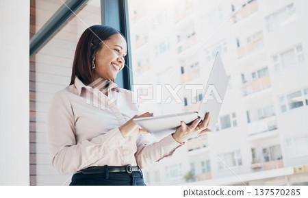 Happy woman at office window, holding laptop and reading email, schedule or online for feedback. Internet, networking or communication on website, businesswoman at human resources agency at low angle 137570285