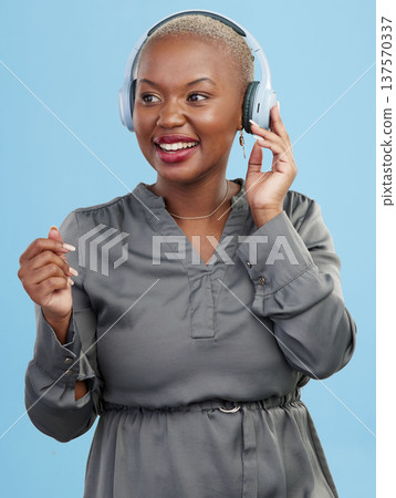 Black woman, headphones and music, dancing and technology with audio streaming isolated on blue background. Listening to radio, wireless tech for podcast and subscription with media in studio 137570337