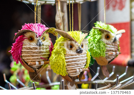 Colorful hanging owl ornaments at craft market Colorful hanging owl ornaments at craft market 137570463