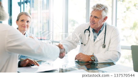 Interview, doctors shaking hands and partnership with team in meeting at hospital, senior physician and agreement. Solidarity, support and healthcare collaboration with medical professional people 137570544