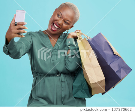 Shopping bag, studio selfie and happy black woman excited for discount promotion, sales and pose for memory photo. Photography, gift and African customer post picture to online app on blue background Shopping bag, studio selfie and happy black woman excited for discount promotion, sales and pose for memory photo. Photography, gift and African customer post picture to online app on blue background 137570662