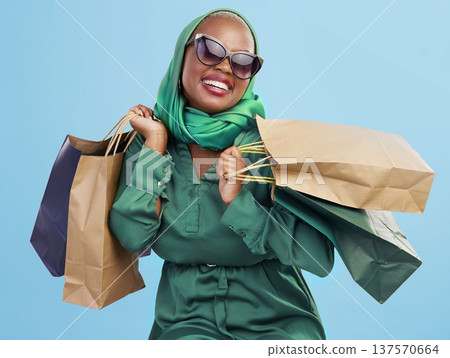Shopping, sunglasses and black woman with bags, excited and boutique products on a blue studio background. African person, customer or model with luxury items, expensive clothes and rich with retail Shopping, sunglasses and black woman with bags, excited and boutique products on a blue studio background. African person, customer or model with luxury items, expensive clothes and rich with retail 137570664