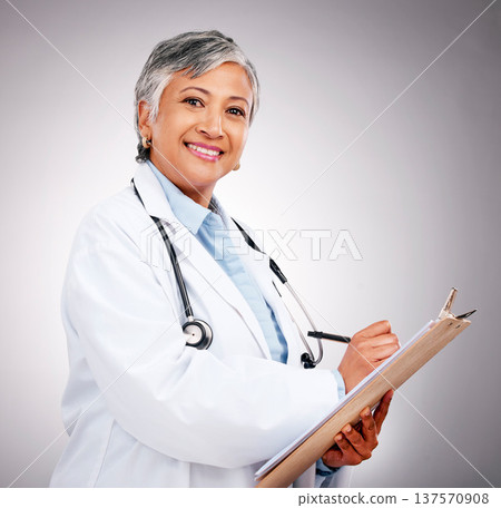 Planning, notes and portrait of woman or doctor writing feedback, healthcare advice or results. Smile, hospital and mature medical employee or nurse with insurance documents on a studio background Planning, notes and portrait of woman or doctor writing feedback, healthcare advice or results. Smile, hospital and mature medical employee or nurse with insurance documents on a studio background 137570908