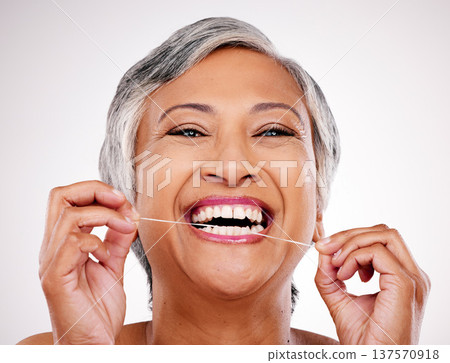 Senior woman, dental floss and studio portrait for healthcare, beauty and cleaning mouth by white background. Mature female model, teeth whitening and thread for self care, breath and healthy smile 137570918