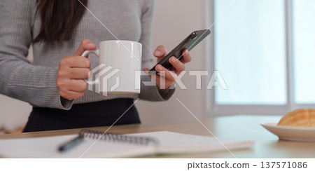 Morning routine: Enjoying coffee and smartphone interaction 137571086