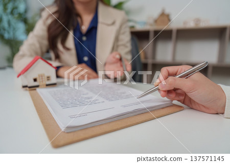 Real Estate Agreement. Client signing documents during home purchase consultation. 137571145