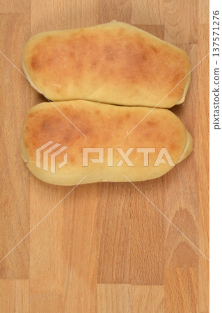 Two freshly baked long rolls on a wooden background 137571276