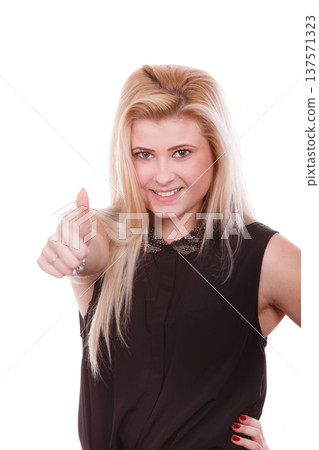 Smiling blonde woman making thumb up gesture 137571323