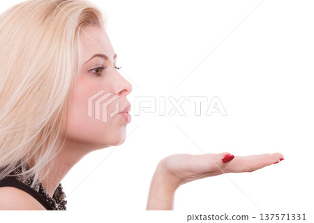 Blonde woman sending air kiss on palm hand 137571331